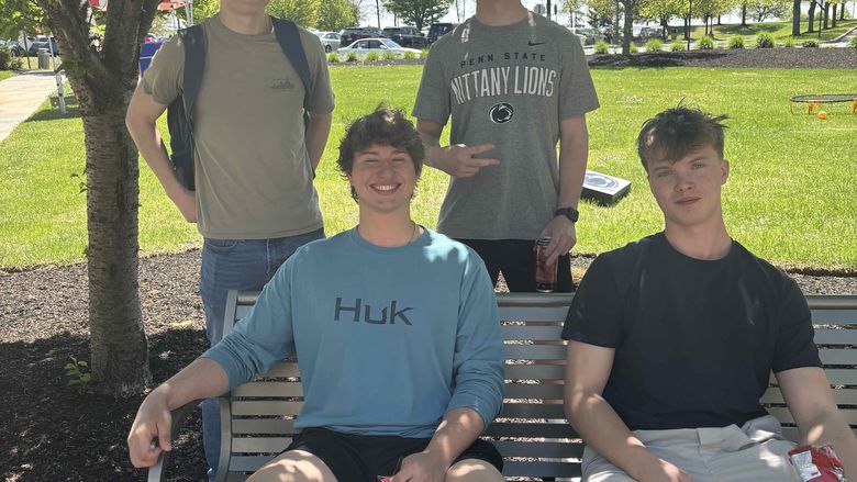 students smiling on bench 