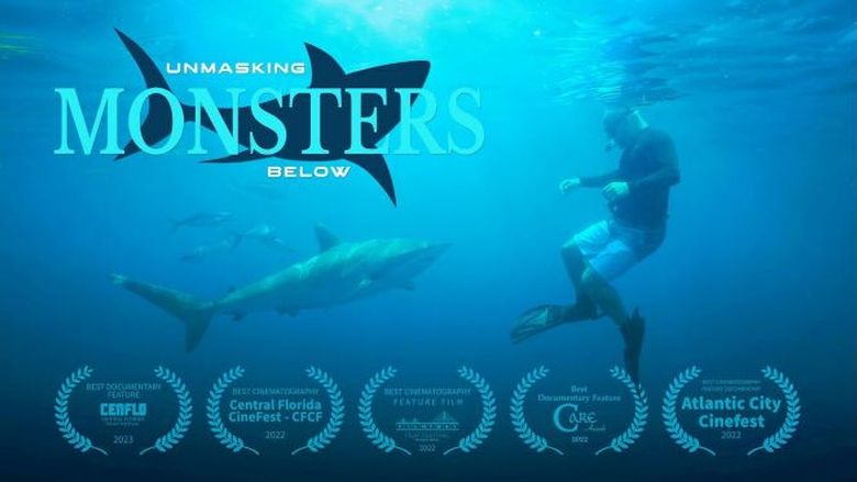 Underwater photo of a man wearing a snorkel, mask, and fins swimming with sharks.