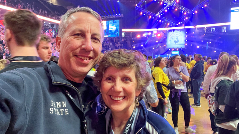 Bob Smyrl and Debbie Zuech-Smyrl on the floor among the dancers during THON 2023 at Penn State's Bryce Jordan Center. 