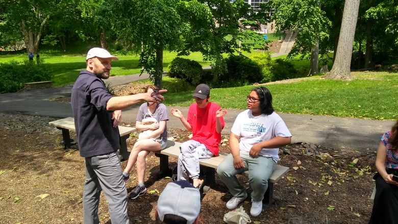 Artist talking to students outside