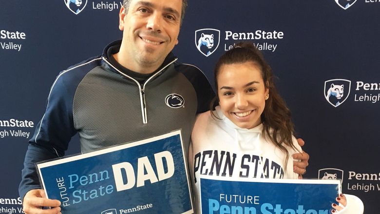 a Dad and daughter pose with Penn State Lehigh Valley signs