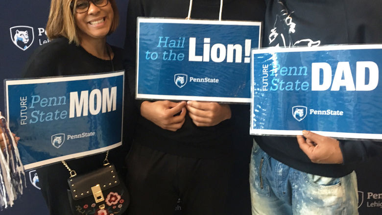 a son with his parents holding PSU signs