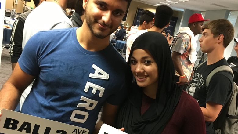 Two students holding signs they made at Blue and White Bash