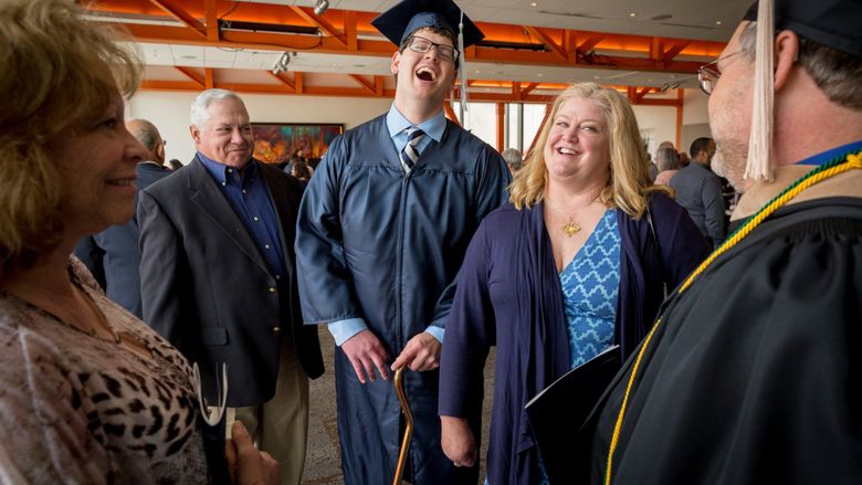 a graduate smiling with his parents