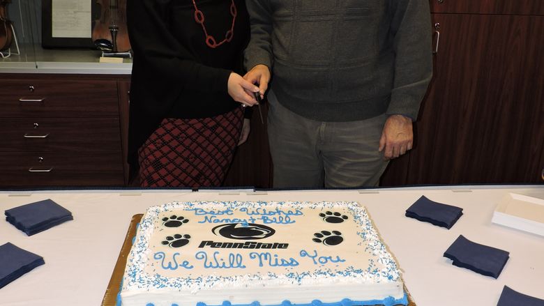 Two people cutting cake