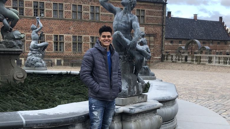 Jermain Jones stands in courtyard at castle in Denmark during study abroad trip over spring break