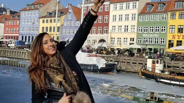 young woman posing in front of traditional buildings in Denmark