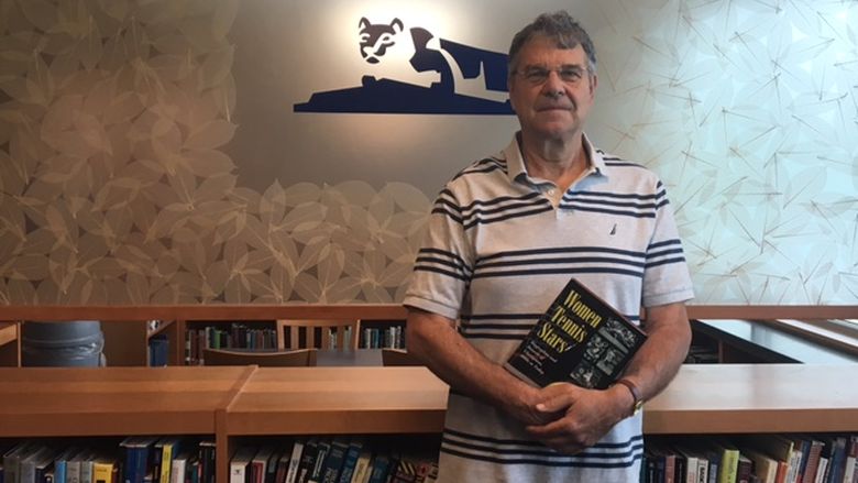 man standing in front of books 