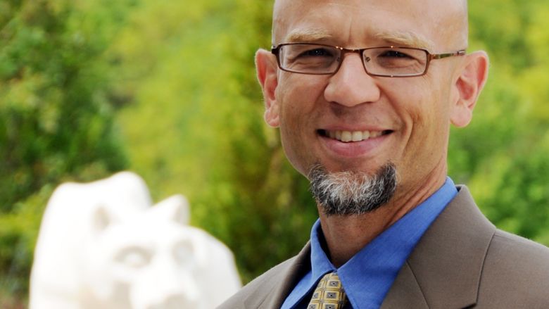 head shot of man in front of nittany lion shrine