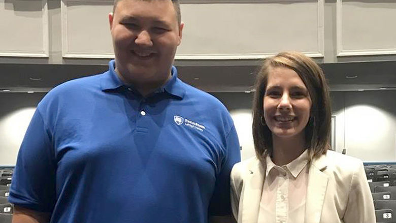 a student standing next to employer smiling