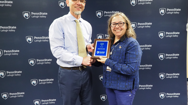 man giving plaque to woman