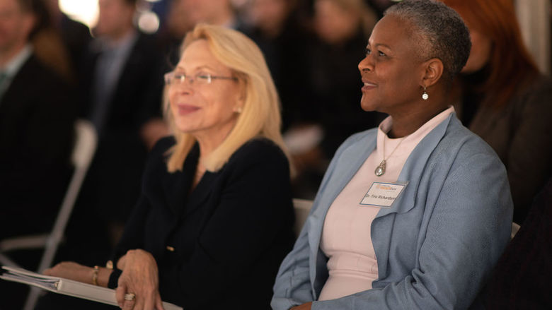 two women listening to speaker