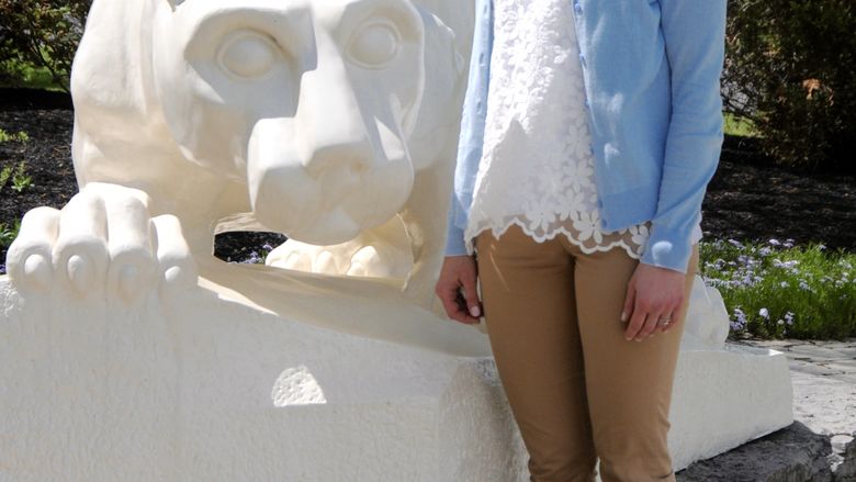 Woman standing in front of lion shrine