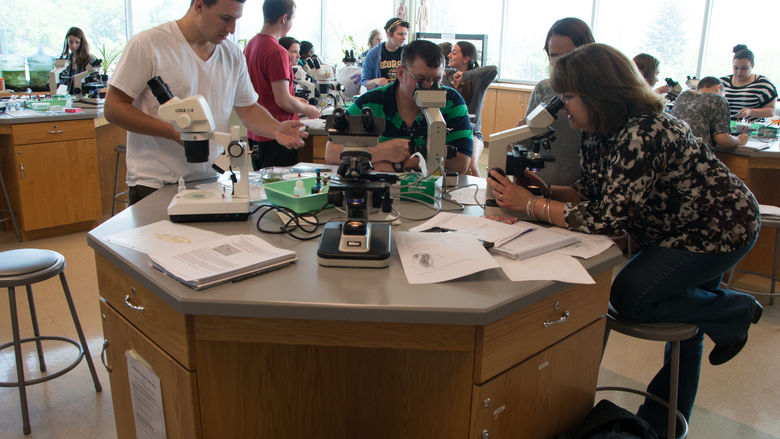 A group gathered around a lab table
