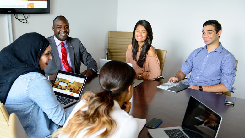 Group of young adults working around a conference table