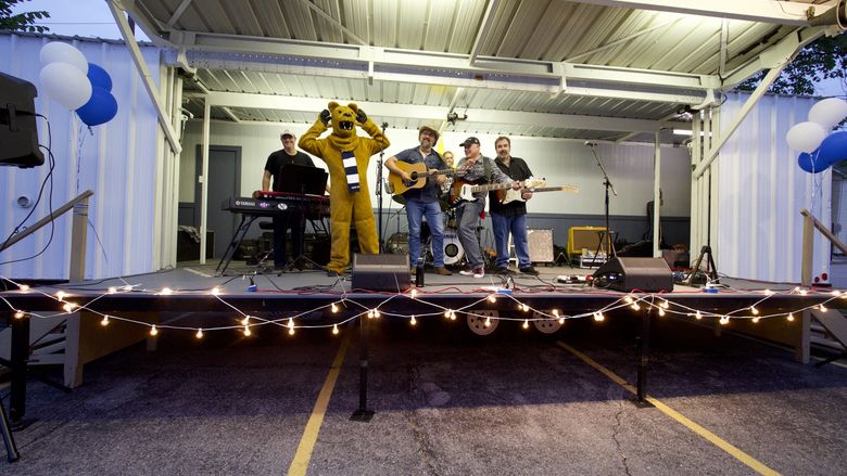 the nittany lion on stage with a band