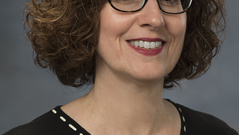 head shot of woman with curly brown hair