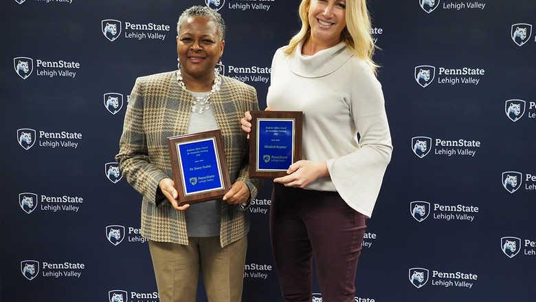 two women each holding a plaque