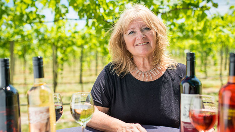 Woman sitting at table in vineyard