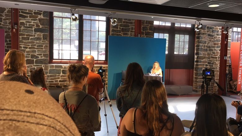 A group gathers at a press conference for Sabrina Carpenter