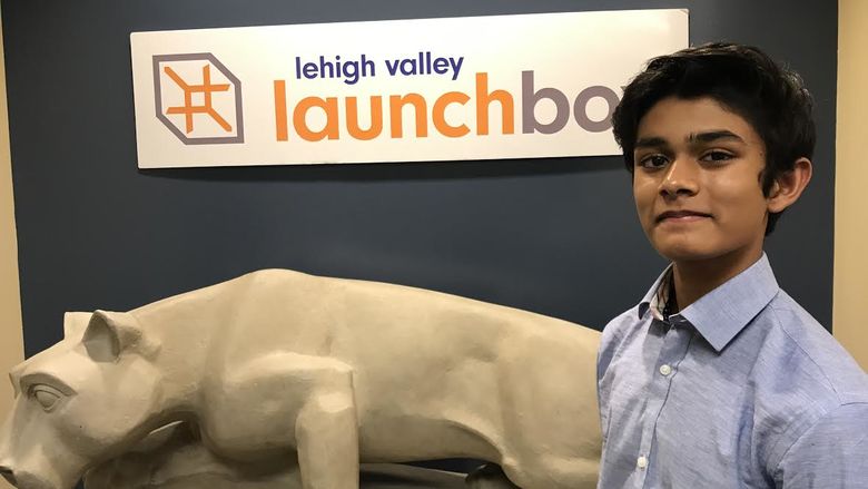 student in front of lion statue