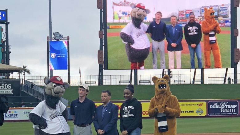 Nittany Lion on baseball field with students and FeRROUS, the IronPigs mascot 