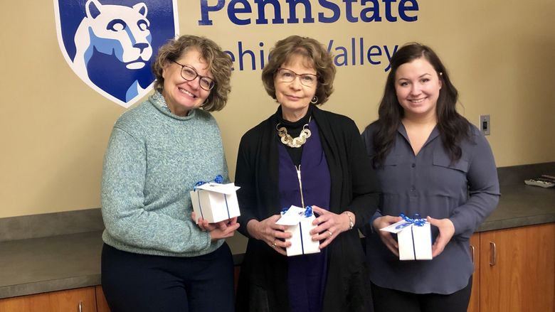 three women holding gift boxes