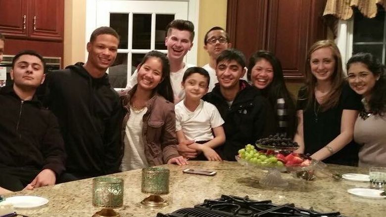 A group of students around a kitchen island