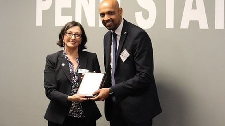 woman handing award to man