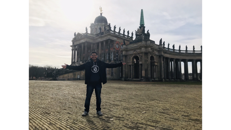 student in front of a German building