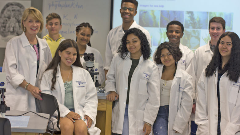 campers in lab coats in a lab with professor