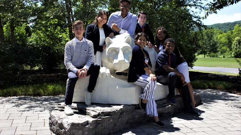 group of students posed around Nittany Lion shrine