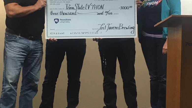 Two men presenting THON check