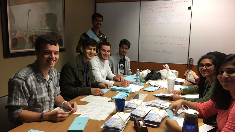 students around a table stuffing envelopes
