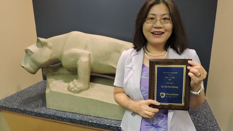woman stands with her award