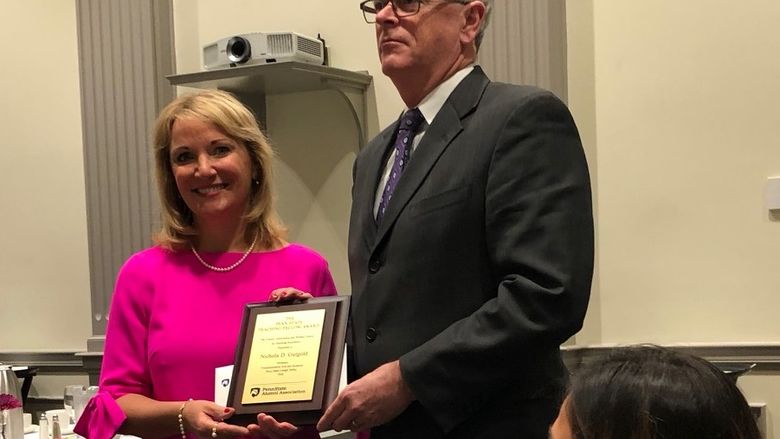 Woman receiving a plaque award from a man