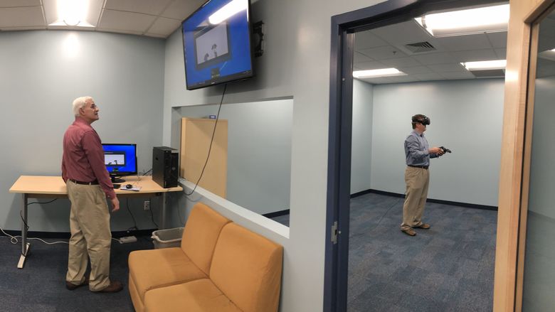 faculty member tries on VR goggles in new room