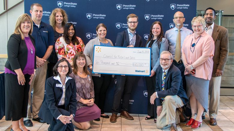 Group of employees from Penn State Lehigh Valley and Walmart standing with large signed check