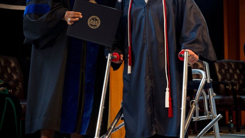 a woman and a man with a walker on stage