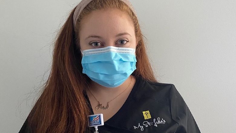 young woman in scrubs and face mask
