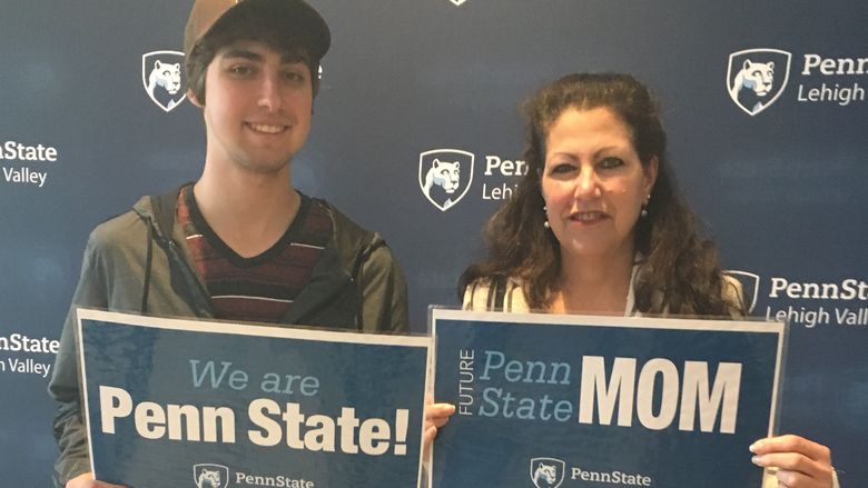 a man and woman holding penn state signs