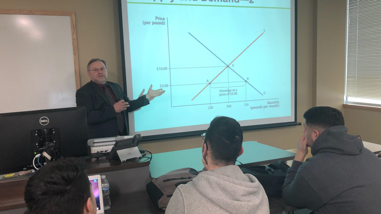 man pointing at screen teaching class