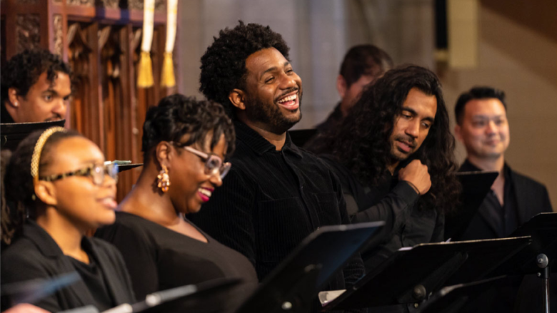 Several members of a choir singing joyously together