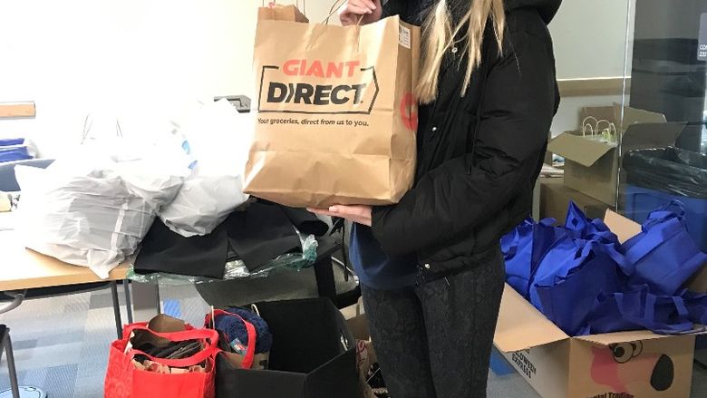 Victoria Stopper holds clothing bag donation 