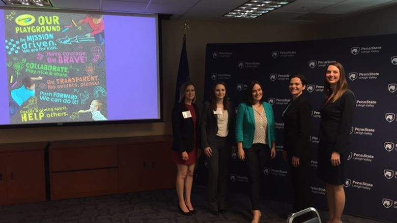 event committe and keynote speaker in front of backdrop