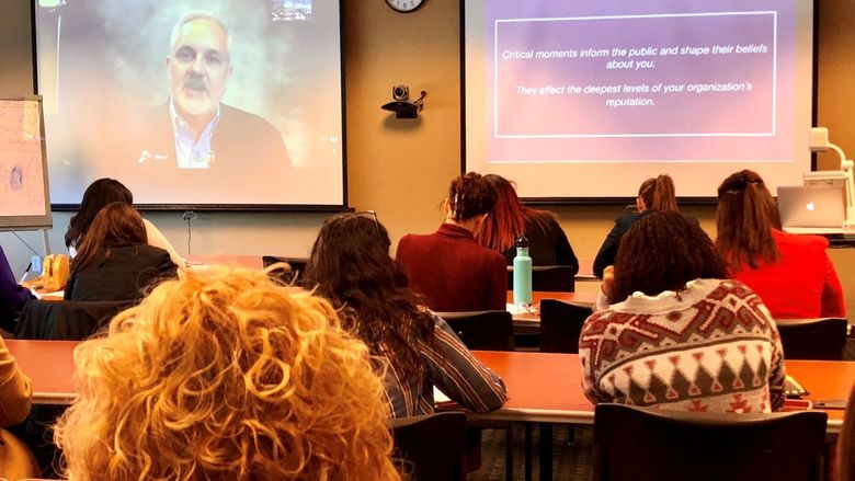 Students listening to a presenter on Zoom screen