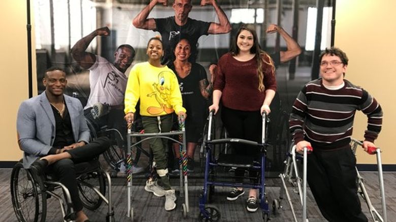 four students in a wheelchair or using walkers