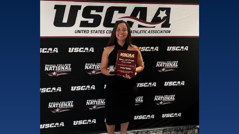 A college student holding an award