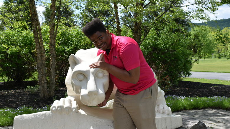 boy standing at Nittany Lion Shrine