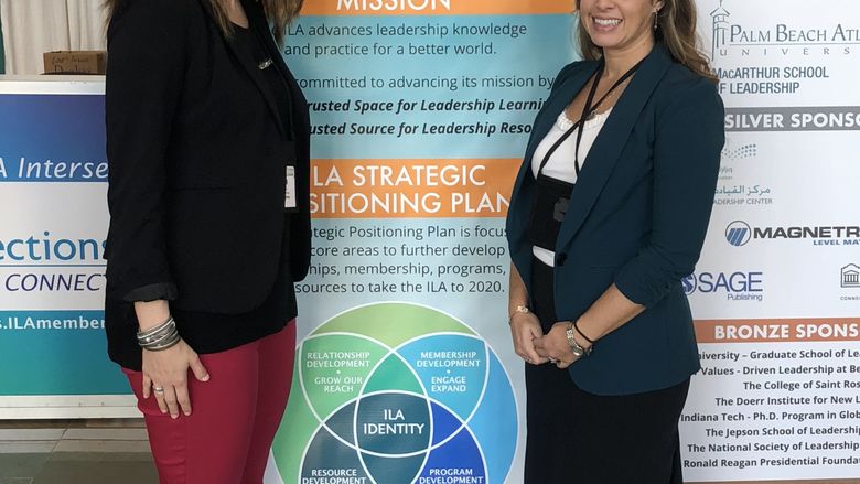 two professors in front of a poster